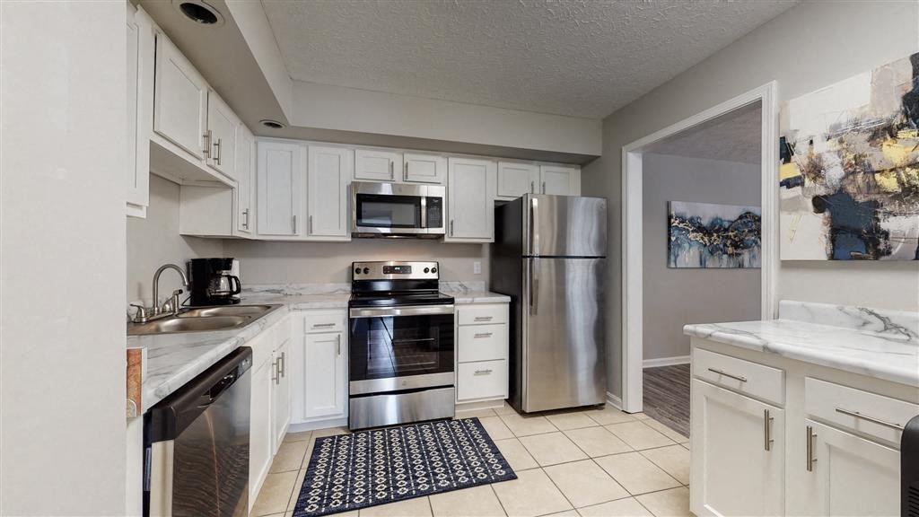 a kitchen with stainless steel appliances and white cabinets