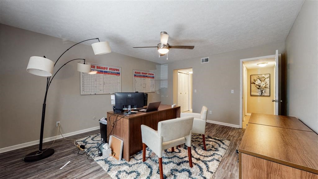 a living room with a desk and a tv