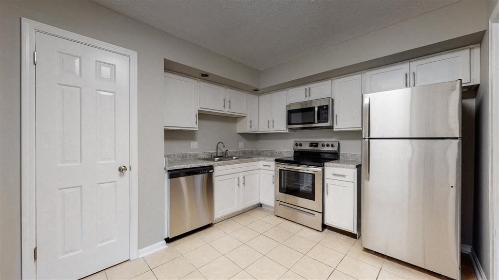 a kitchen with white cabinets and stainless steel appliances