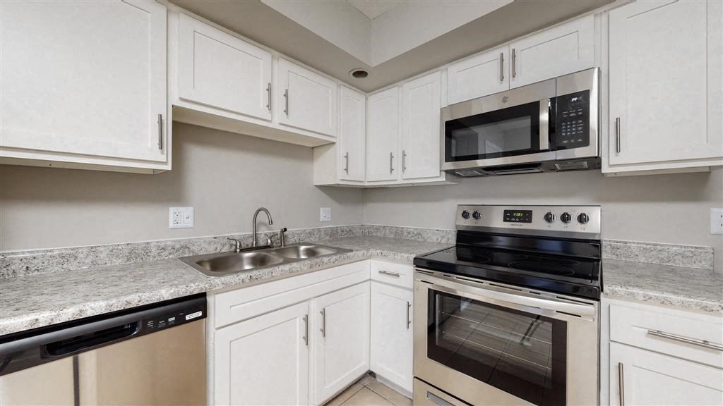 a kitchen with stainless steel appliances and white cabinets