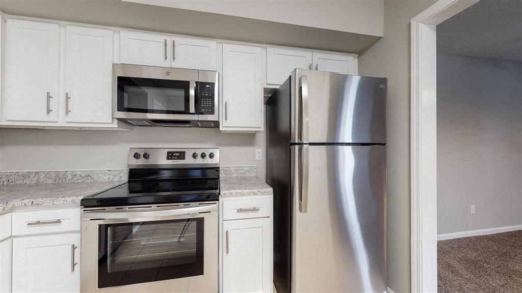 a kitchen with stainless steel appliances and white cabinets