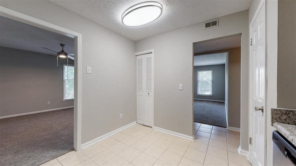 an empty living room with an open door to a bedroom