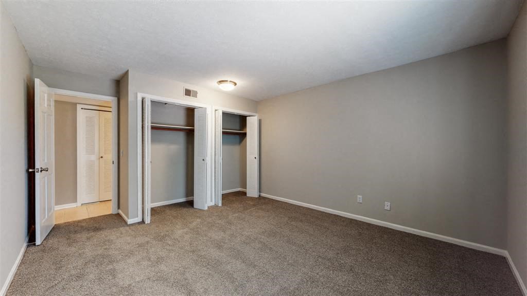 an empty living room with a door to a closet