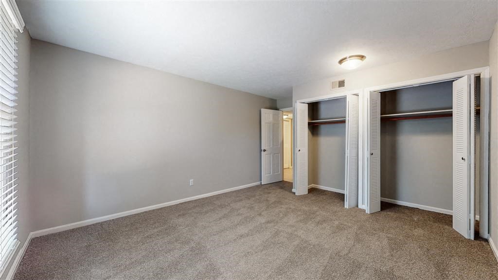 a bedroom with a closet and a door to a bathroom