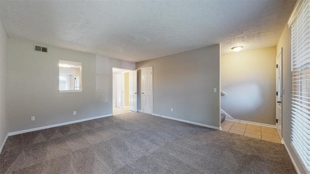 an empty living room with a door to a hallway