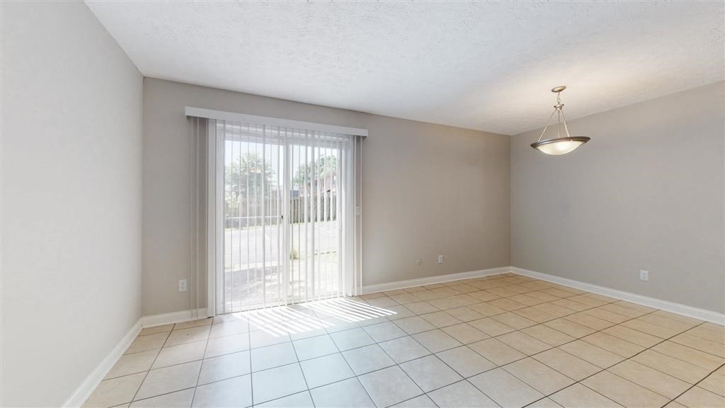 an empty living room with a sliding glass door to a patio