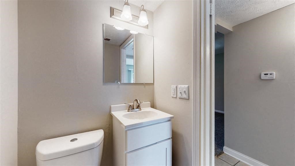 a bathroom with a toilet sink and a mirror