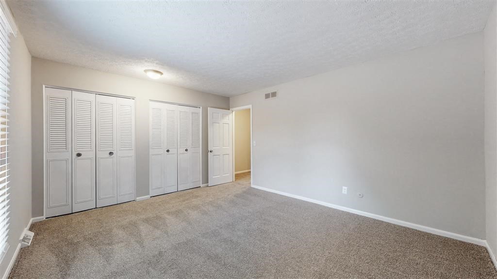 an empty living room with white closet doors