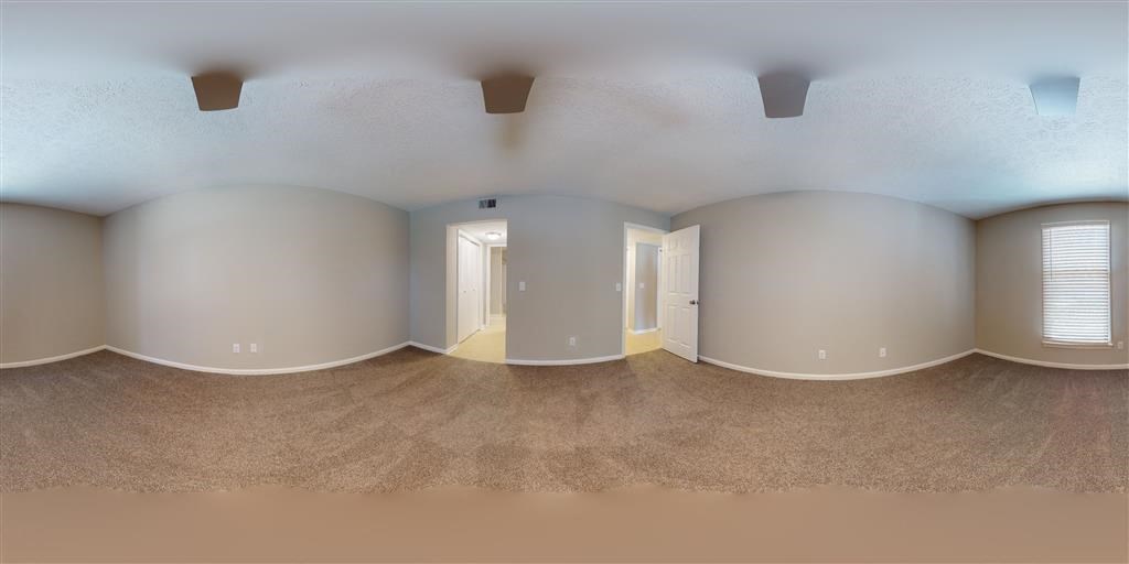 an empty living room with white walls and beige carpet