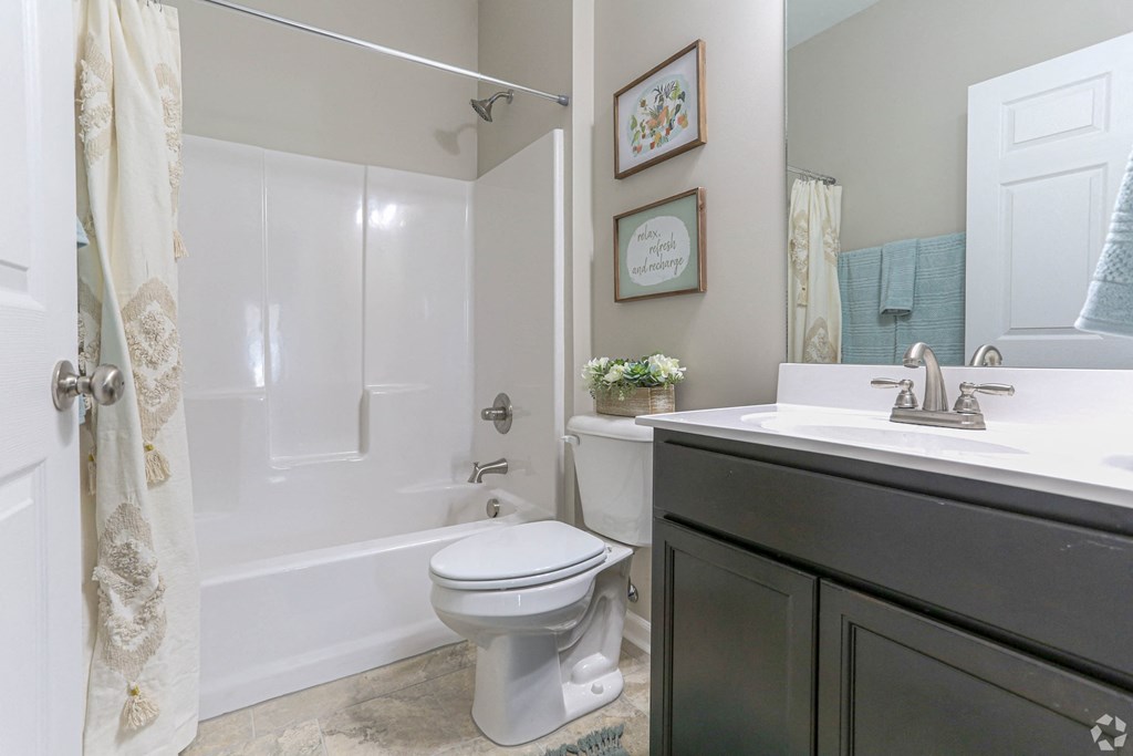 a bathroom with a shower and a sink and a toilet