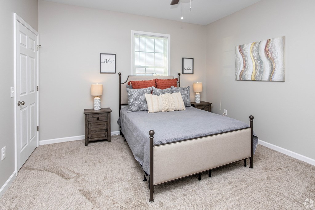 a bedroom with a bed and two lamps and a window