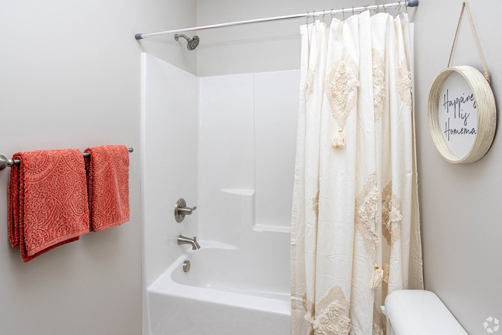 a bathroom with a shower and a toilet and a shower curtain