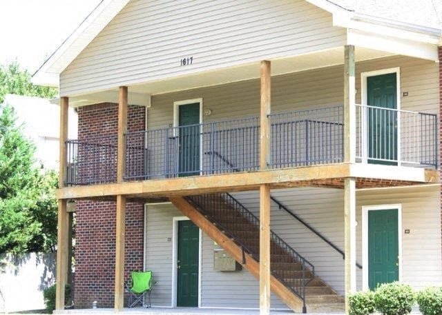 a house with a porch with stairs and a balcony