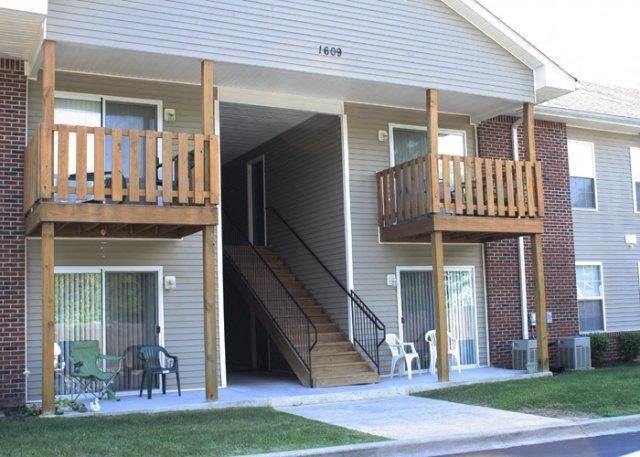 a house with stairs and a porch with chairs
