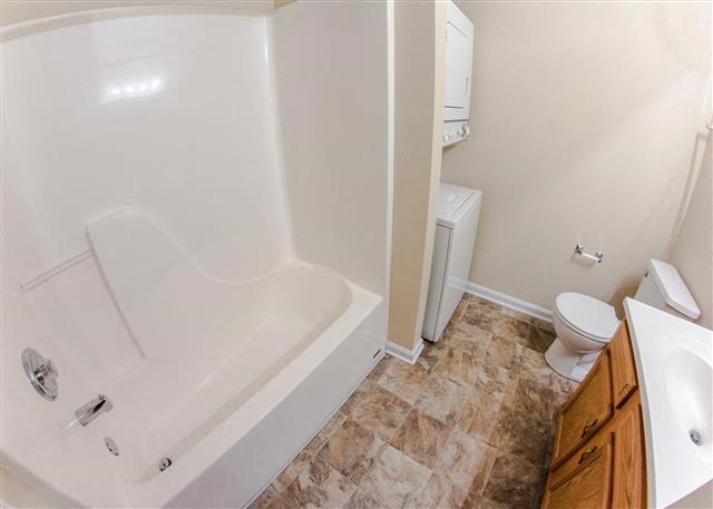 a bathroom with a tub and a toilet and a sink