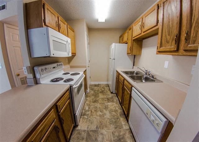 a kitchen with white appliances and wooden cabinets