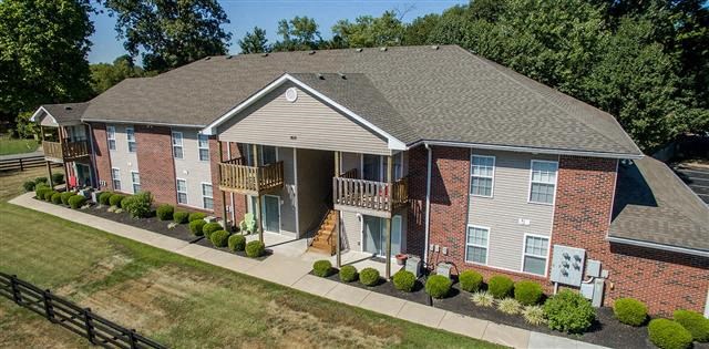 an aerial view of a brick house with a porch