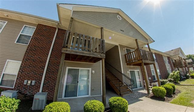 an apartment building with stairs and a balcony