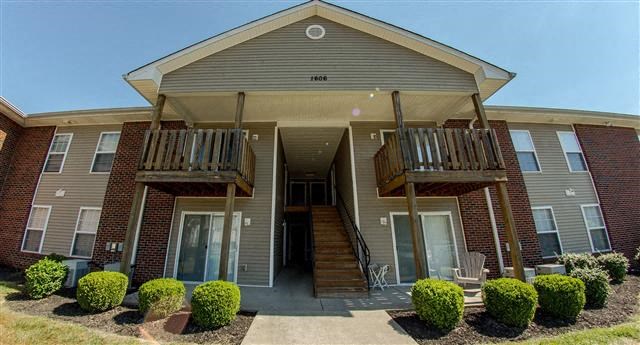 an apartment building with stairs and a balcony
