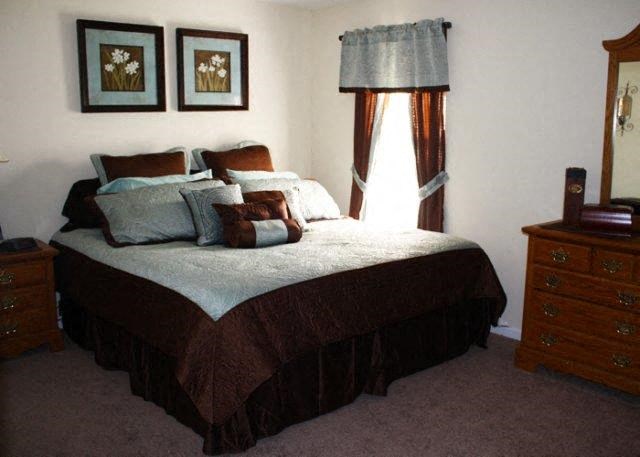 a bedroom with a bed and two pictures on the wall
