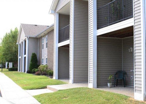 a gray house with a patio and a grill