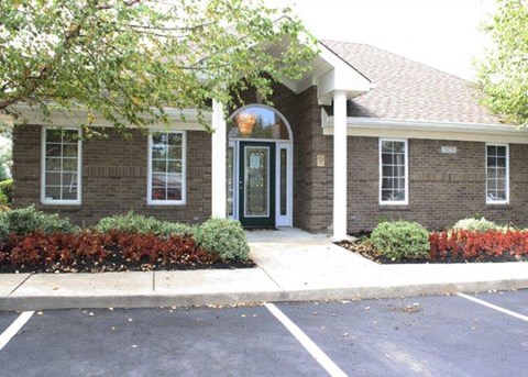a brick house with a black door and a driveway