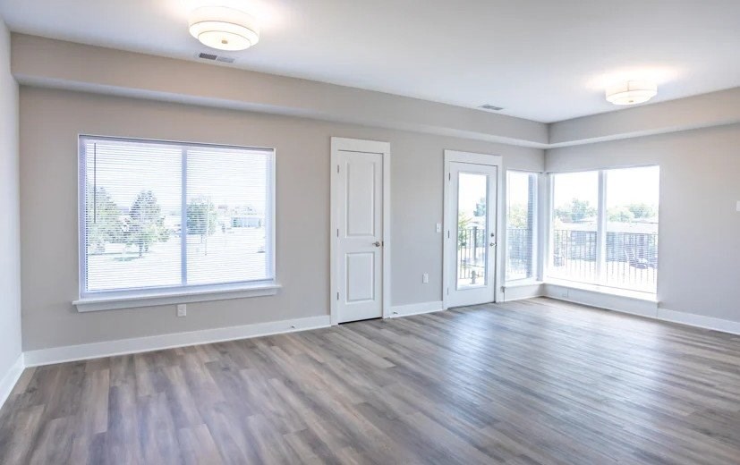 A room with wooden flooring and a large window.