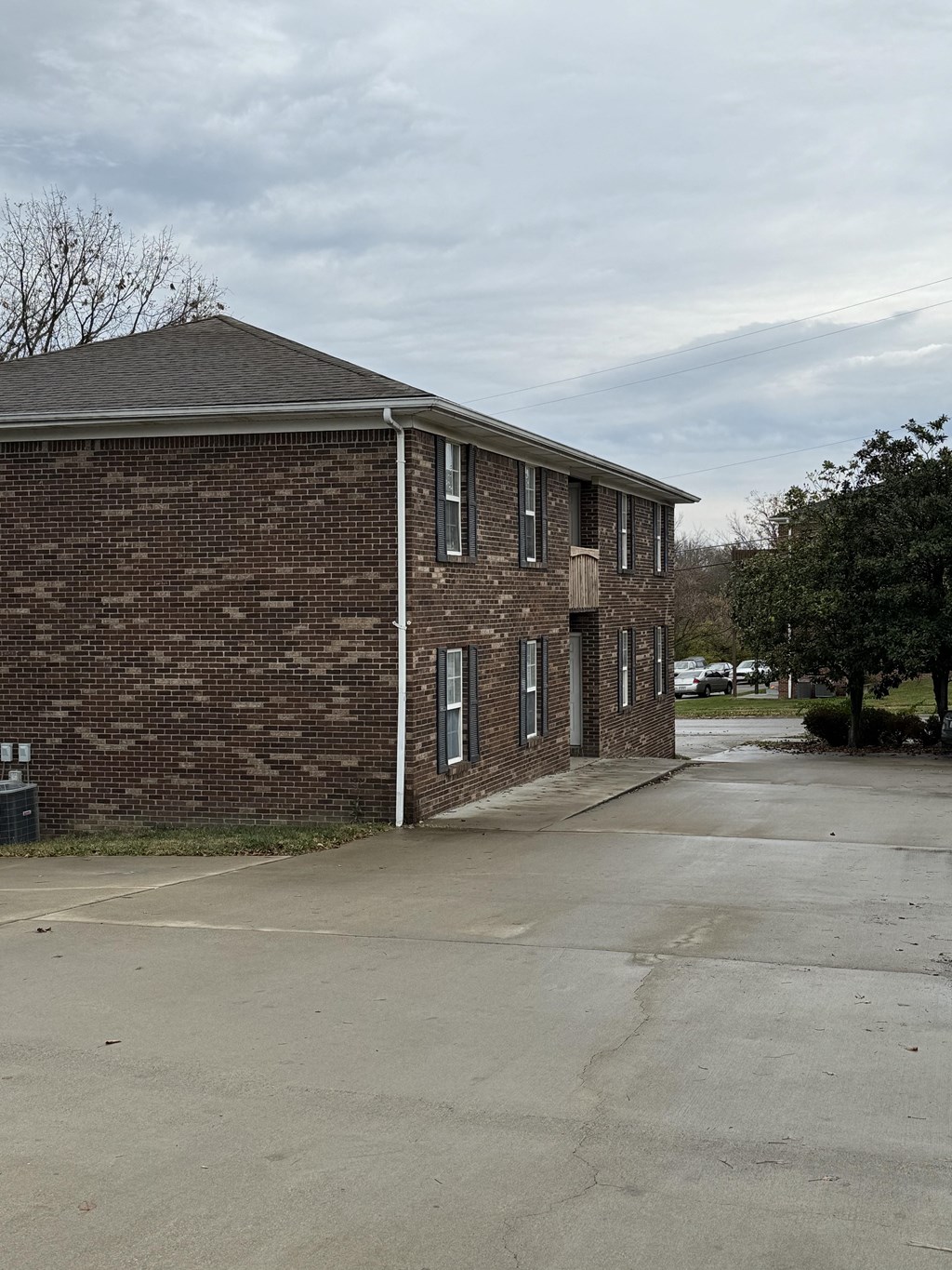 a small brick building with a driveway in front of it