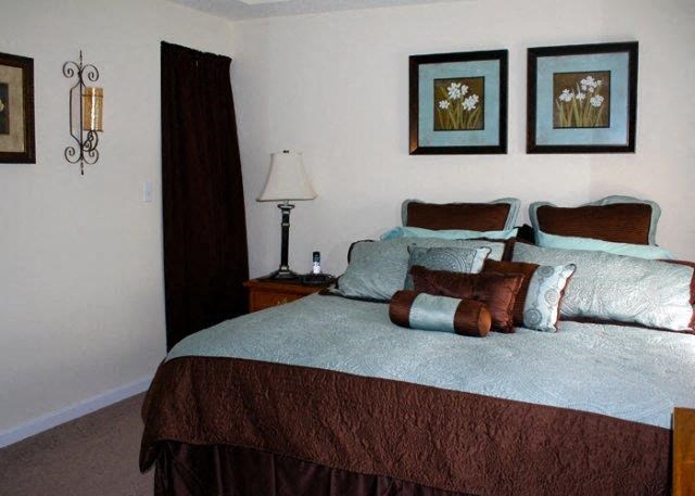 a bedroom with a bed and two pictures on the wall