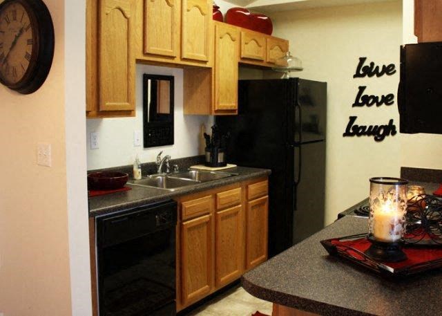 a kitchen with black appliances and a candle