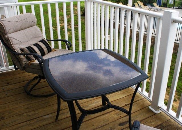 a patio table with a reflection of the sky on it