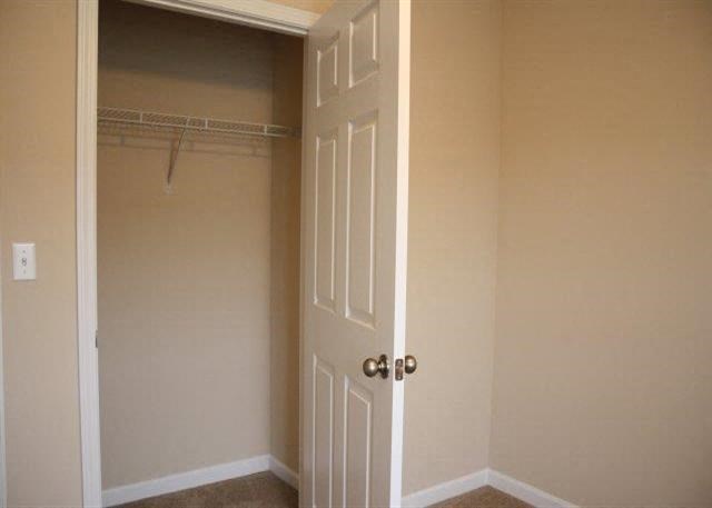 an empty closet with a white door and a white closet door