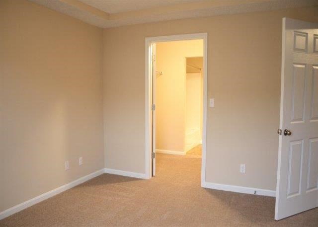 an empty living room with a door to a bedroom