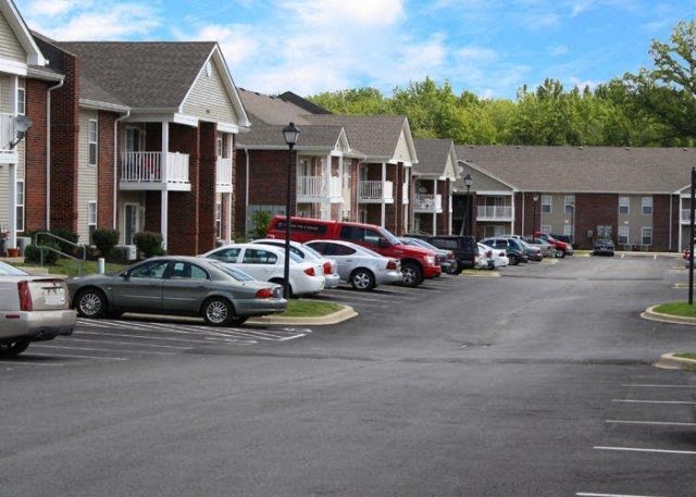 a parking lot filled with cars in front of houses