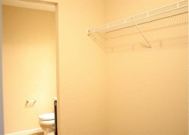 a bathroom with a toilet and a rack on the wall