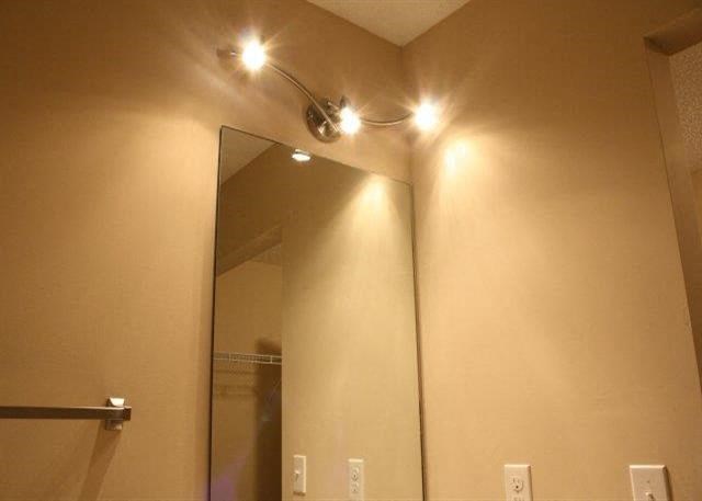 a bathroom with a mirror and lights on the wall