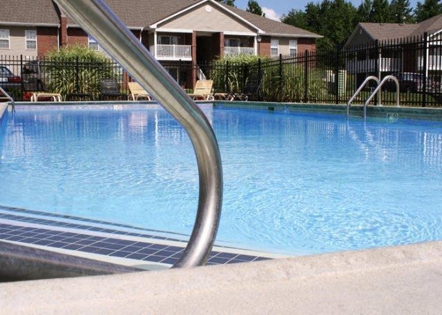 a large swimming pool with a metal railing