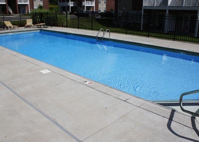 a large blue swimming pool next to a fence