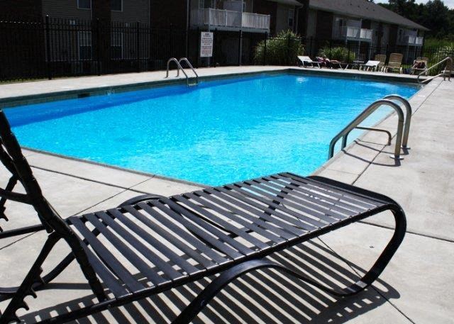a swimming pool with a bench next to it