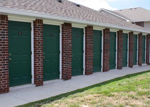 a row of garages with green doors on a house