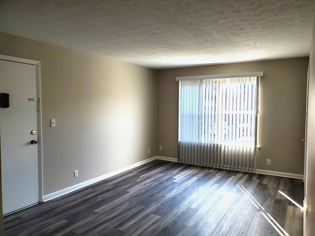 A room with a white door and a window with blinds.