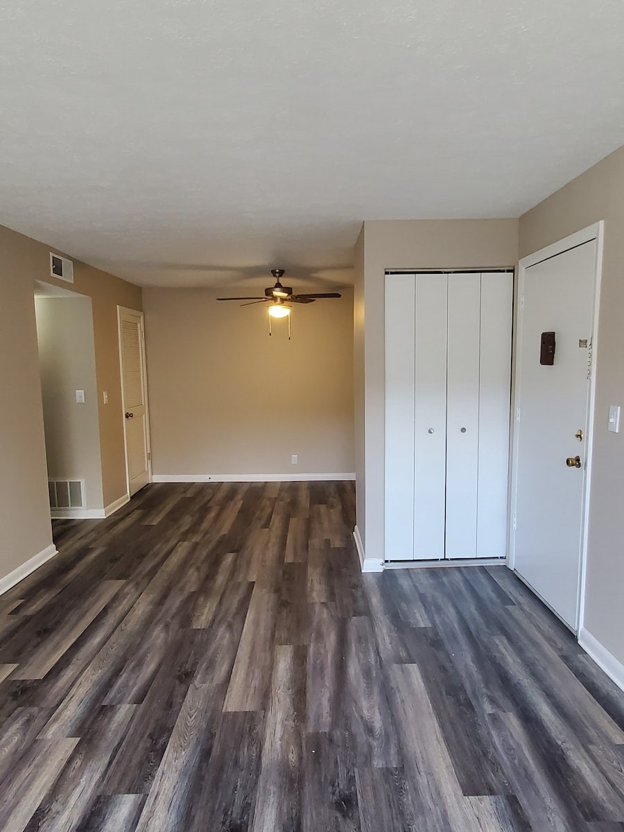 A room with a ceiling fan and two doors.