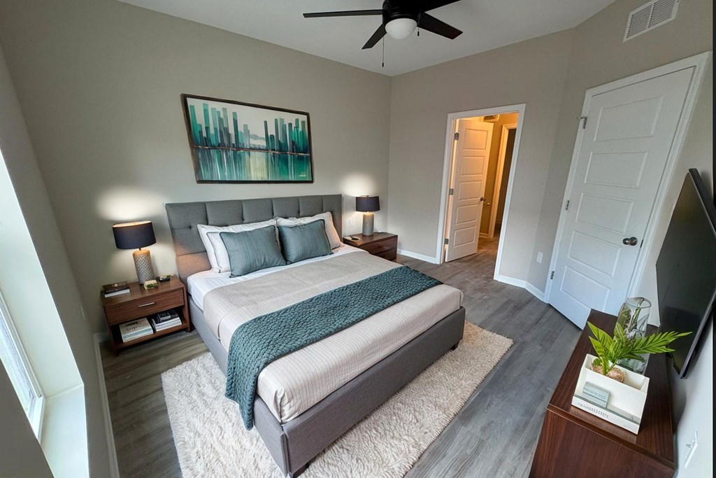 A bedroom with a large bed and a ceiling fan.