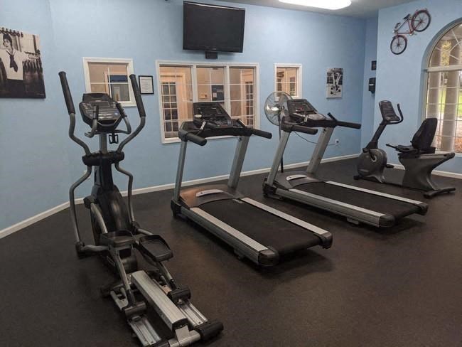 a group of exercise machines in a room with a television