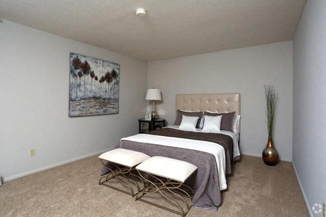 a bedroom with a bed and two chairs