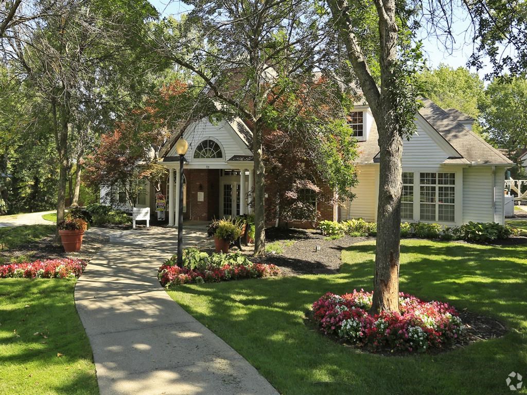 a house with a sidewalk and trees in front of it