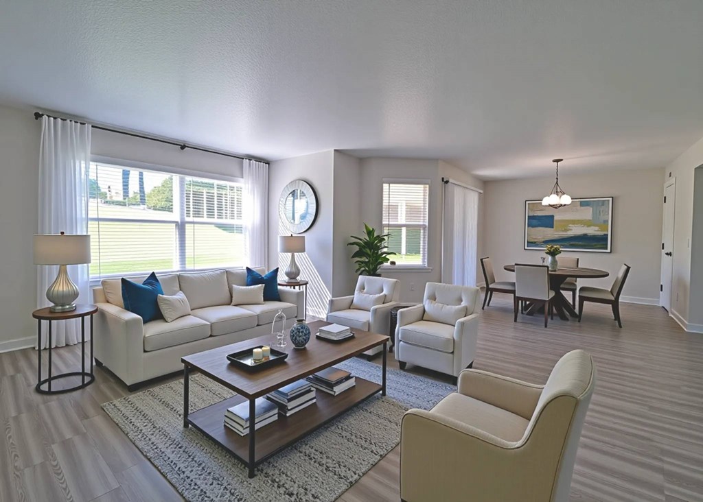 A living room with a white sofa, a white armchair, and a coffee table.