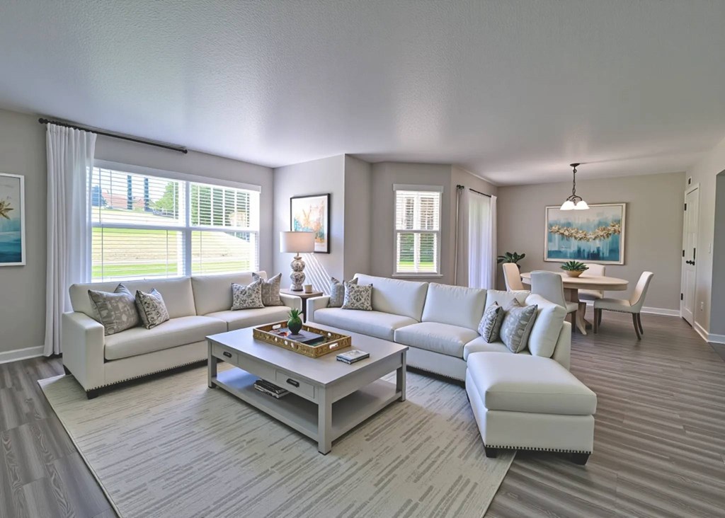 A living room with a white couch, a coffee table, and a painting on the wall.