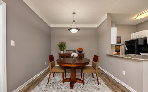 A dining room with a wooden table and chairs.
