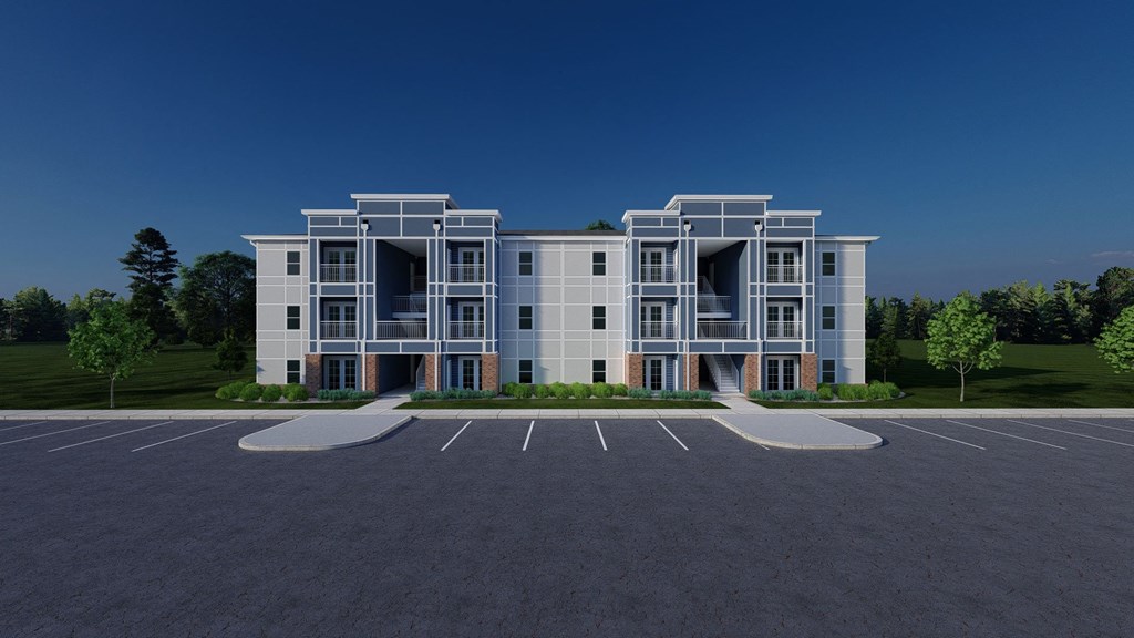 A modern building with a parking lot in front.